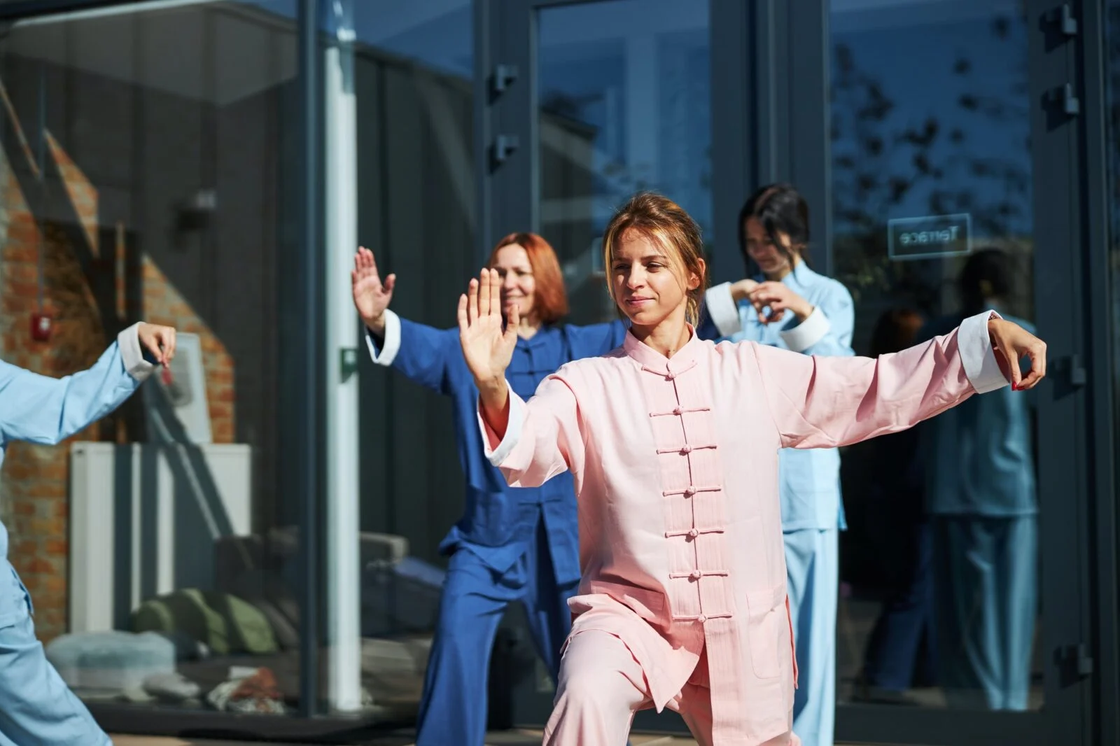 Groupe de personnes pratiquant le Qi Gong en vêtements traditionnels.